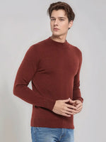 Young man in 98degreenorth Men’s Maroon Merino Wool Turtle Neck Sweater and blue jeans stands against a light background.
