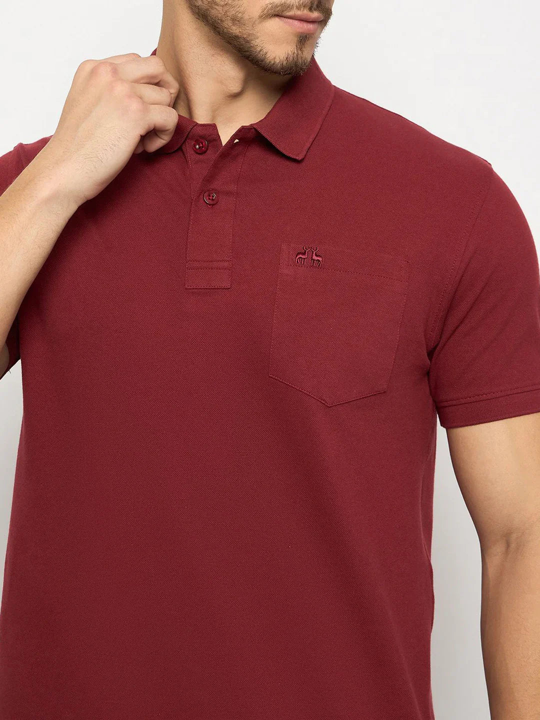 Man in 98degreenorth Men's Maroon Polo, stretch cotton pique, chest pocket, touching collar, mid-torso view.
