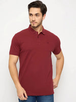 Man wears 98degreenorth Men's Maroon Solid Polo T-Shirt — Cotton Pique with blue jeans against a white background.