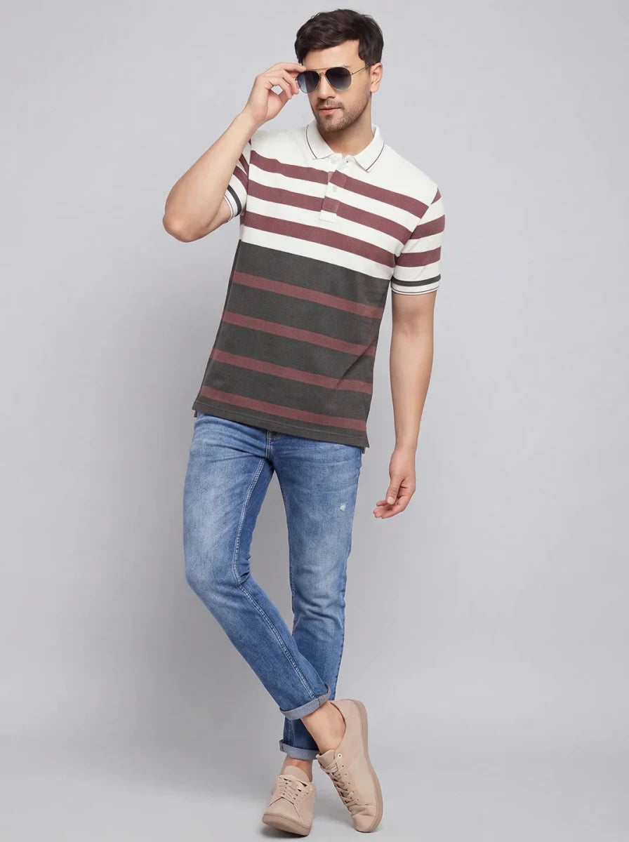 Man wearing 98degreenorth Men's Mauve Olive Striped Pique Knit Polo, blue jeans, and beige shoes with sunglasses.