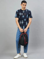 Man in a Men's Navy Abstract Ikat Print T-Shirt by 98degreenorth, blue jeans, and white sneakers holding a backpack.