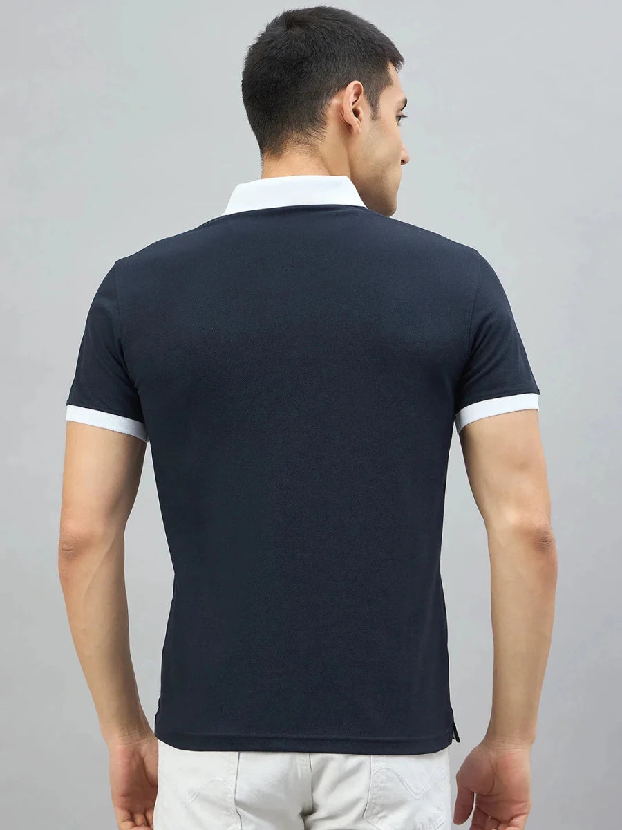 Man facing away, wearing a 98degreenorth Men's Navy Aeronorth KC-767A Aviation Polo T-Shirt with light pants.