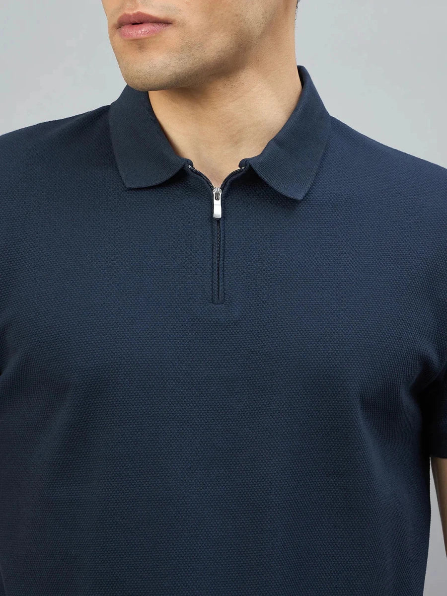 A man wears a 98degreenorth Men's Navy Blue Quarter Zip Polo T-Shirt—Popcorn Knit, shown shoulders to mid-chest.