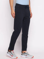 Man in 98degreenorth Men’s Navy Fleece Trackpants, classic joggers for gym or travel, with grey-red sneakers.