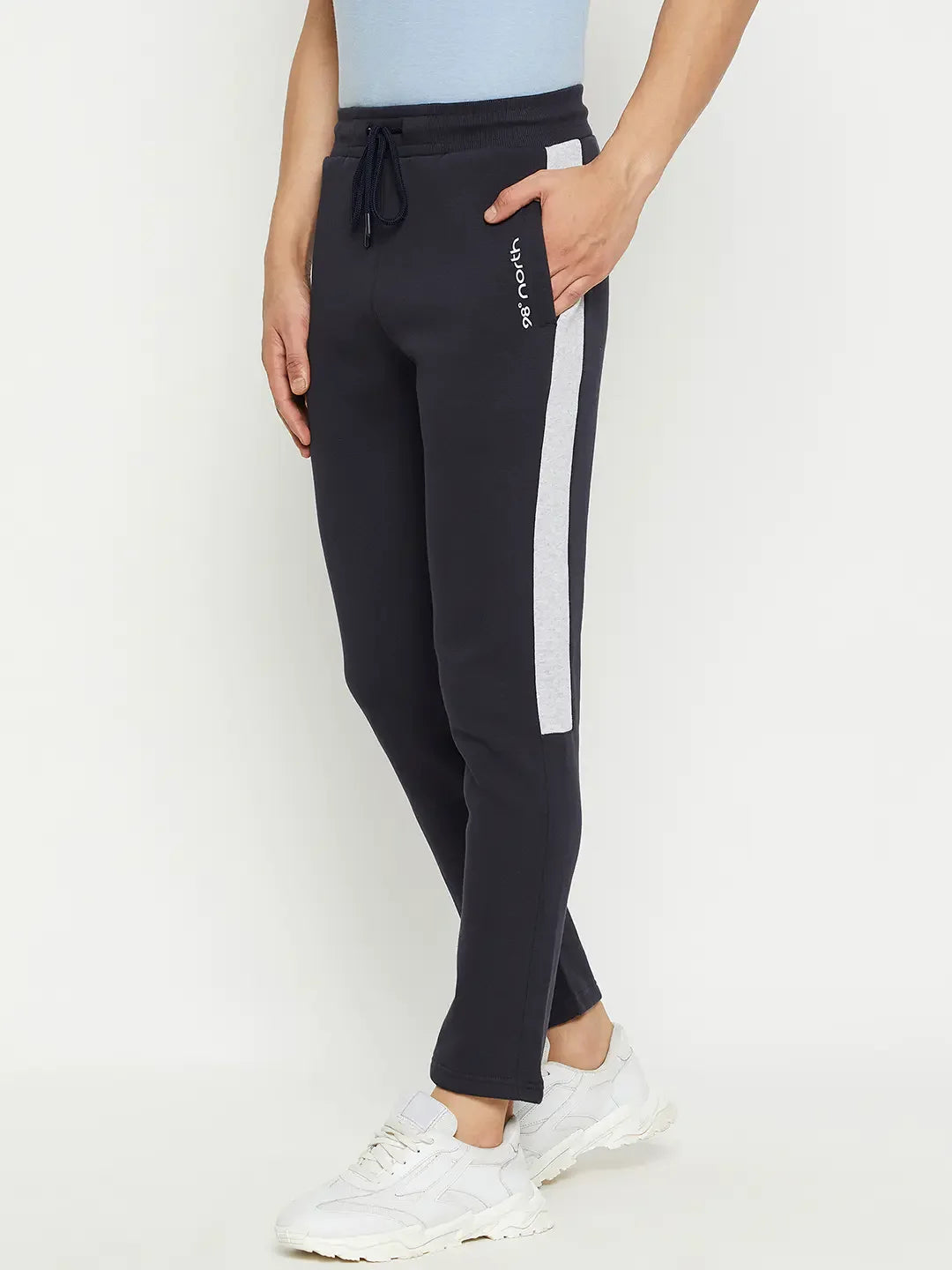 A person in 98degreenorth Men’s Navy Fleece Trackpants with Contrast Side Stripe, white sneakers, and a light blue top.