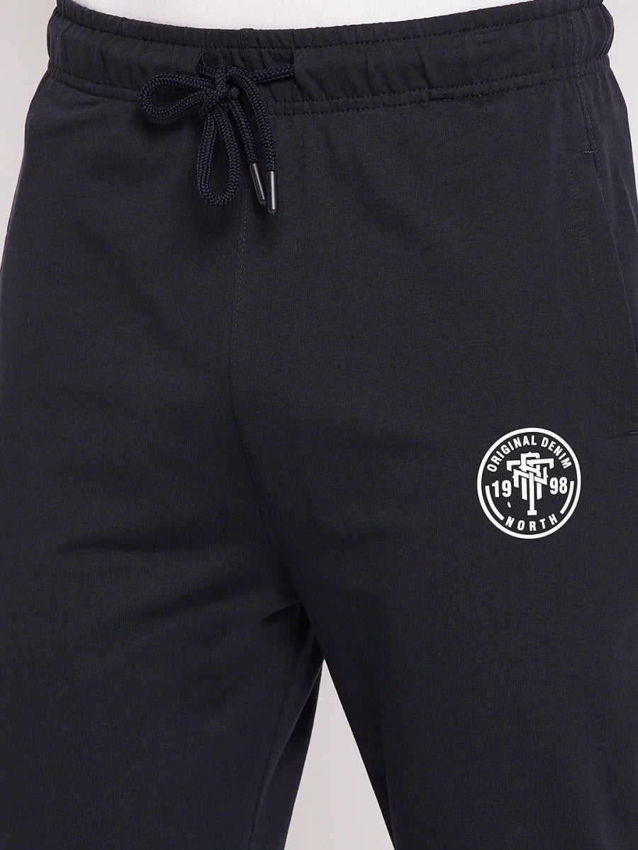 Close-up of 98degreenorth Men's Navy French Terry Lycra Trackpants featuring a white logo and drawstring waistband.