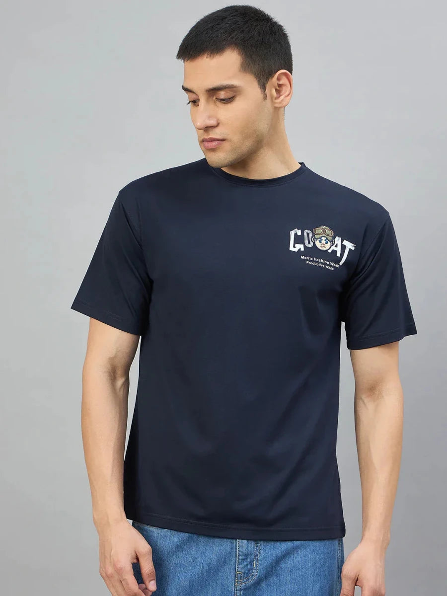 Man wearing 98degreenorth Men's Navy Graphic Oversized T-Shirt—GOAT Back Print, looking down against plain background.