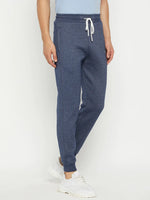 Model in 98degreenorth Men’s Navy Jaspe Fleece Trackpants, white sneakers, light blue tee, on a white background.