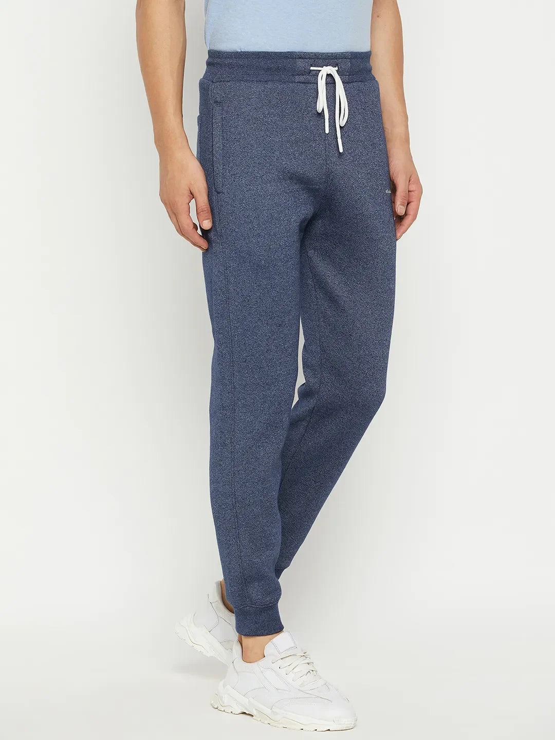 Model in 98degreenorth Men’s Navy Jaspe Fleece Trackpants, white sneakers, light blue tee, on a white background.