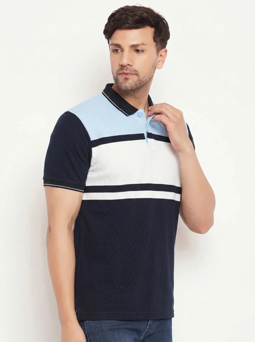 Man in a 98degreenorth Navy Sky Blue Colour Block Pique Polo T-Shirt, paired with jeans, against a plain background.