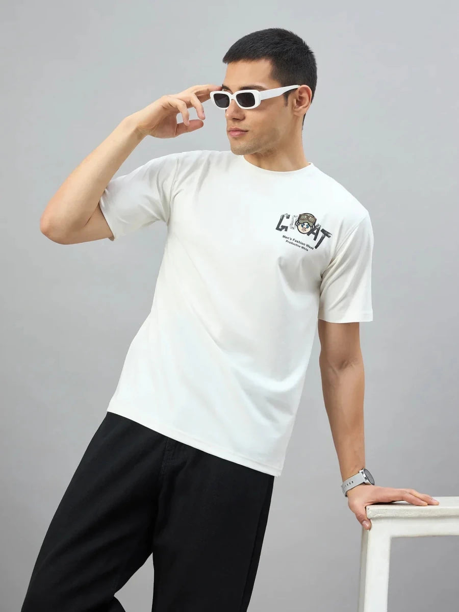 Man in 98degreenorth Men's Off-White Graphic Oversized T-Shirt poses, adjusting sunglasses on a white surface.