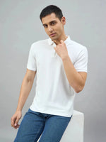 Man wears a 98degreenorth Off-White Quarter Zip Polo T-Shirt — Popcorn Knit, paired with blue jeans, looking at camera.