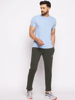 Man in 98degreenorth Olive Fleece Trackpants and gray sneakers, standing against a plain white background.