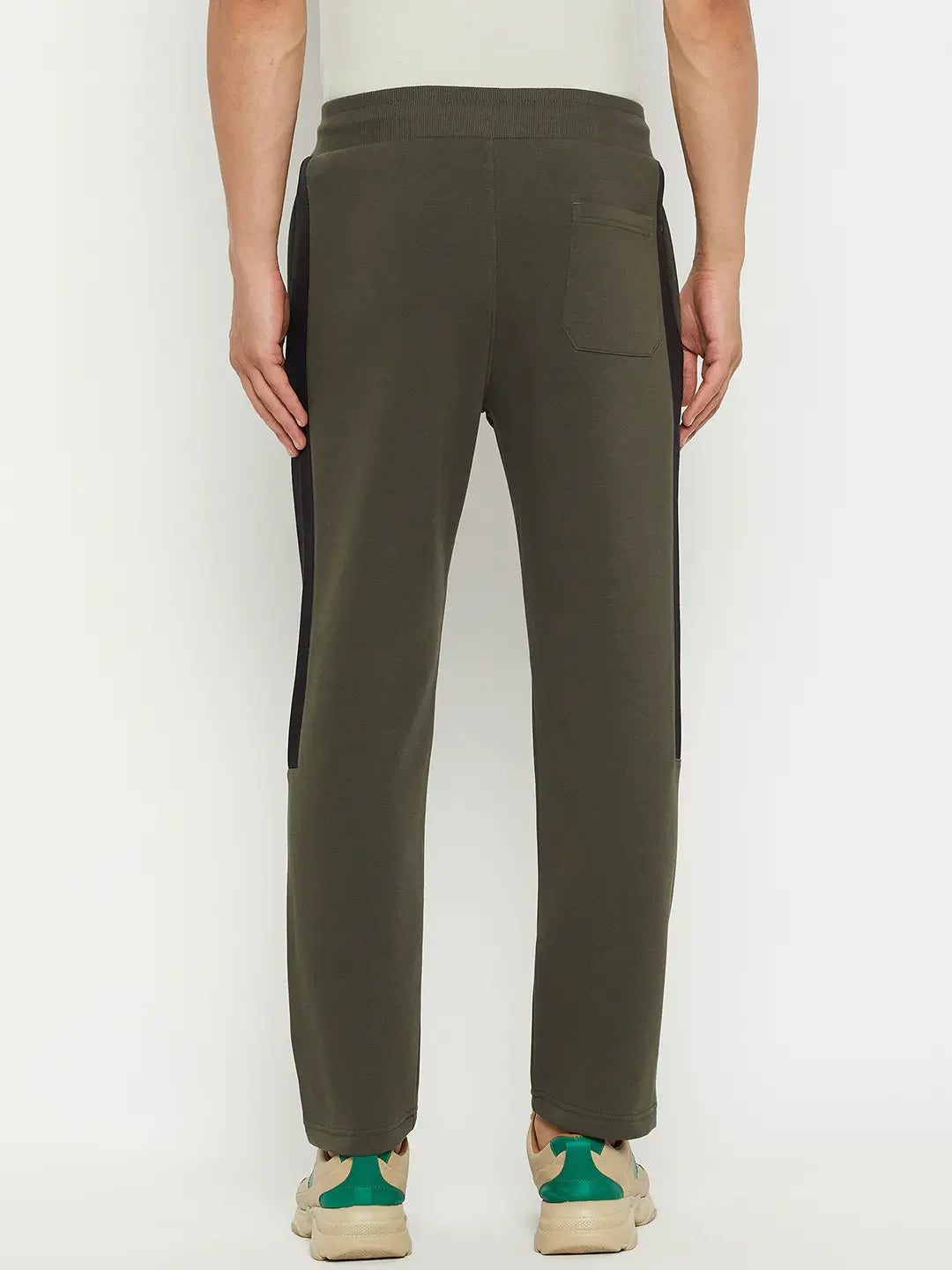 A person wearing 98degreenorth Men’s Olive Fleece Trackpants with black side panel, viewed from the back.