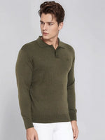 Man wearing 98degreenorth Men’s Olive Merino Wool Polo Neck Sweater and white pants, on a light gray background.