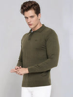 Man in 98degreenorth Olive Merino Wool Polo Neck Sweater, standing against gray background.
