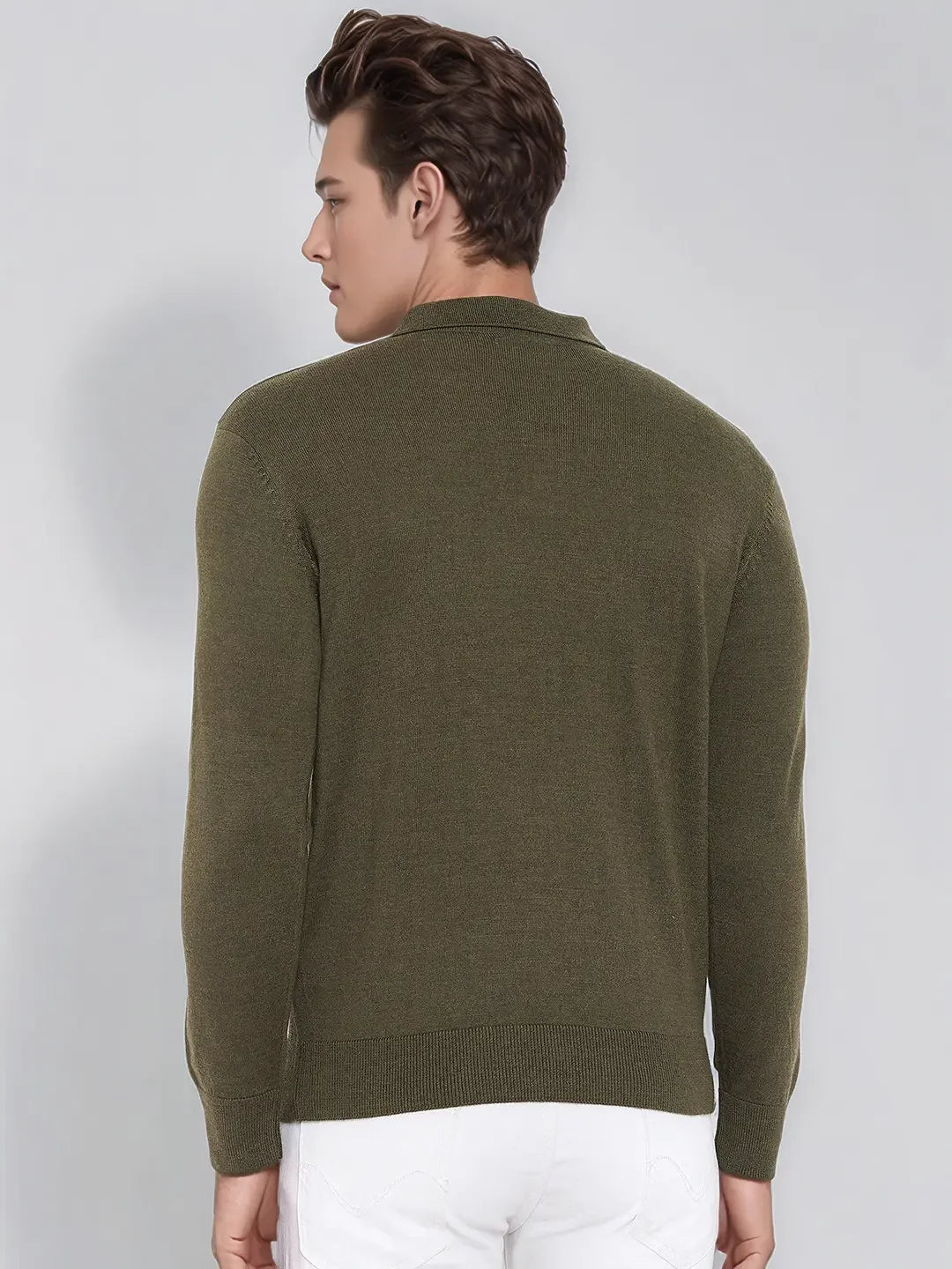 Man in a 98degreenorth Men’s Olive Merino Wool Polo Neck Sweater, elegant pullover, paired with white pants, facing away.