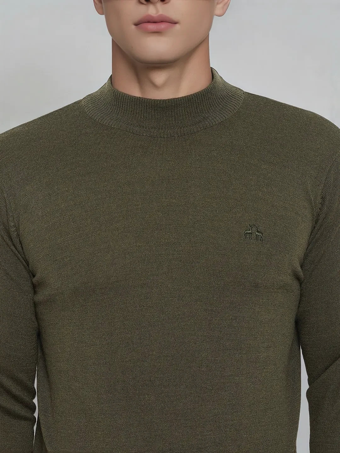 A man in a 98degreenorth olive Merino wool turtleneck sweater with ribbed texture and embroidered crown logo.