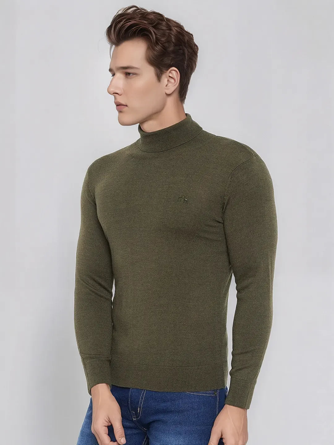 Man in 98degreenorth’s Olive Merino Wool Turtle Neck Sweater and blue jeans, against a light gray background.