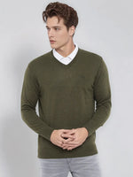 Young man in a 98degreenorth olive merino wool V-neck sweater, white collared shirt, and light gray pants.