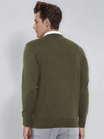 Man in a 98degreenorth Men’s Olive Merino Wool V-Neck Sweater and light gray pants facing away from the camera.