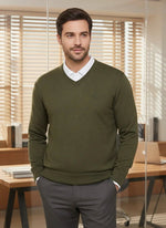 A man wears a 98degreenorth Men’s Olive Merino Wool V-Neck Sweater in a modern office with wood blinds and shelves.