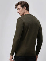 A man wears the 98degreenorth Men’s Olive Merino Wool Sweater, facing away in black pants against a plain background.