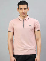 Man in 98degreenorth Men's Pink Polo T-Shirt—Handmade Series with black trim, paired with black pants, on gray backdrop.