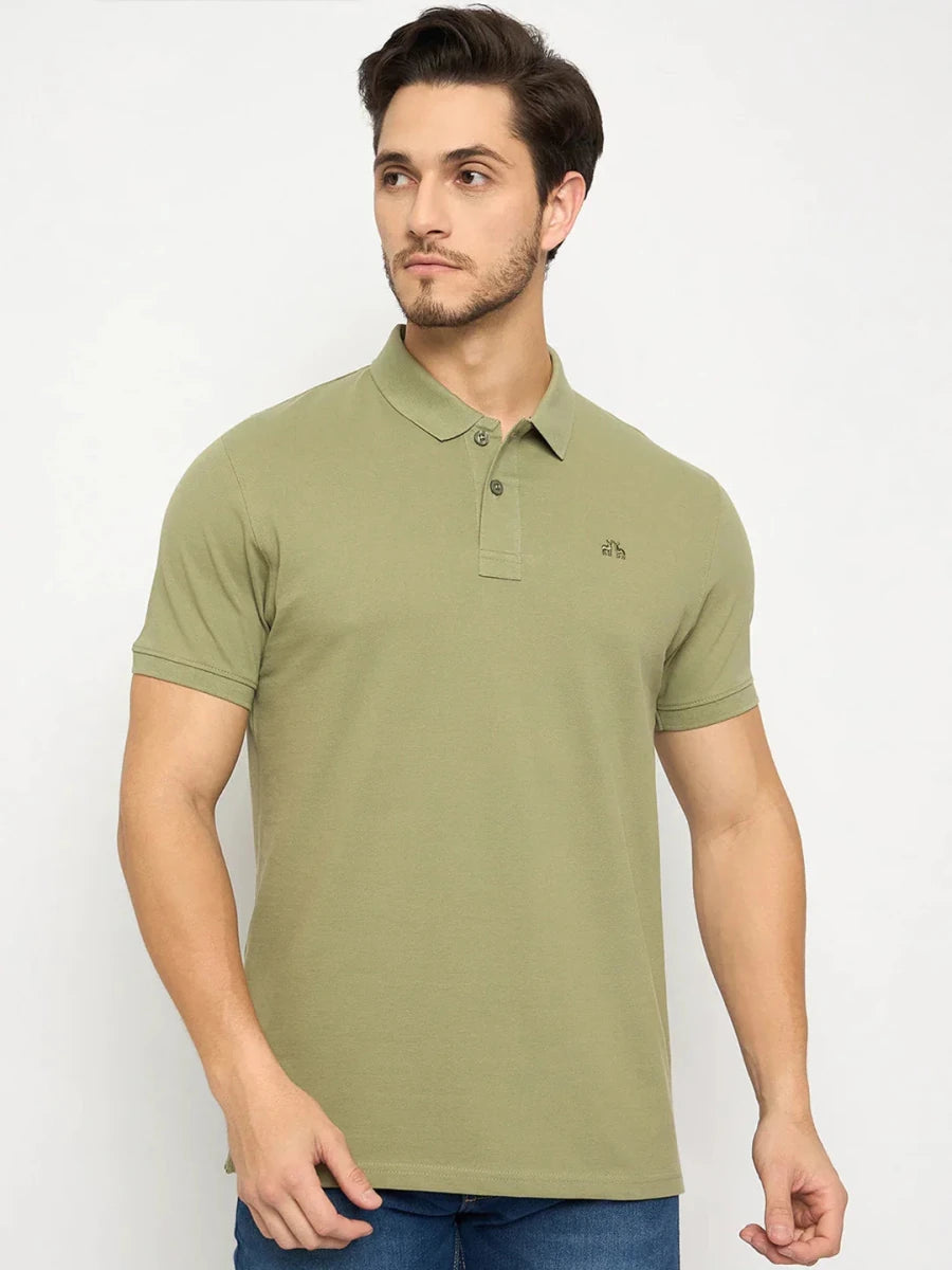 Man in a men's Pista Green Polo T-Shirt by 98degreenorth and blue jeans, posing against a plain white background.