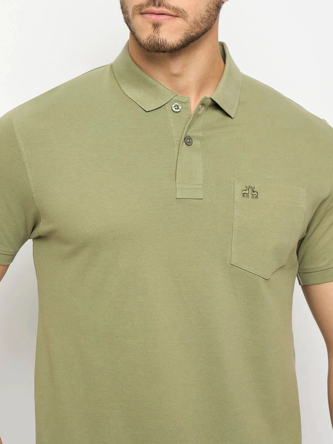 Man in a 98degreenorth Pista Green pure cotton pique polo with chest pocket and small logo above it.