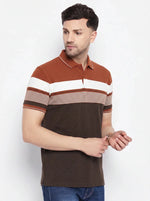 Man wearing 98degreenorth Men's Rust Brown Striped Polo T-Shirt with blue jeans, standing against a white background.