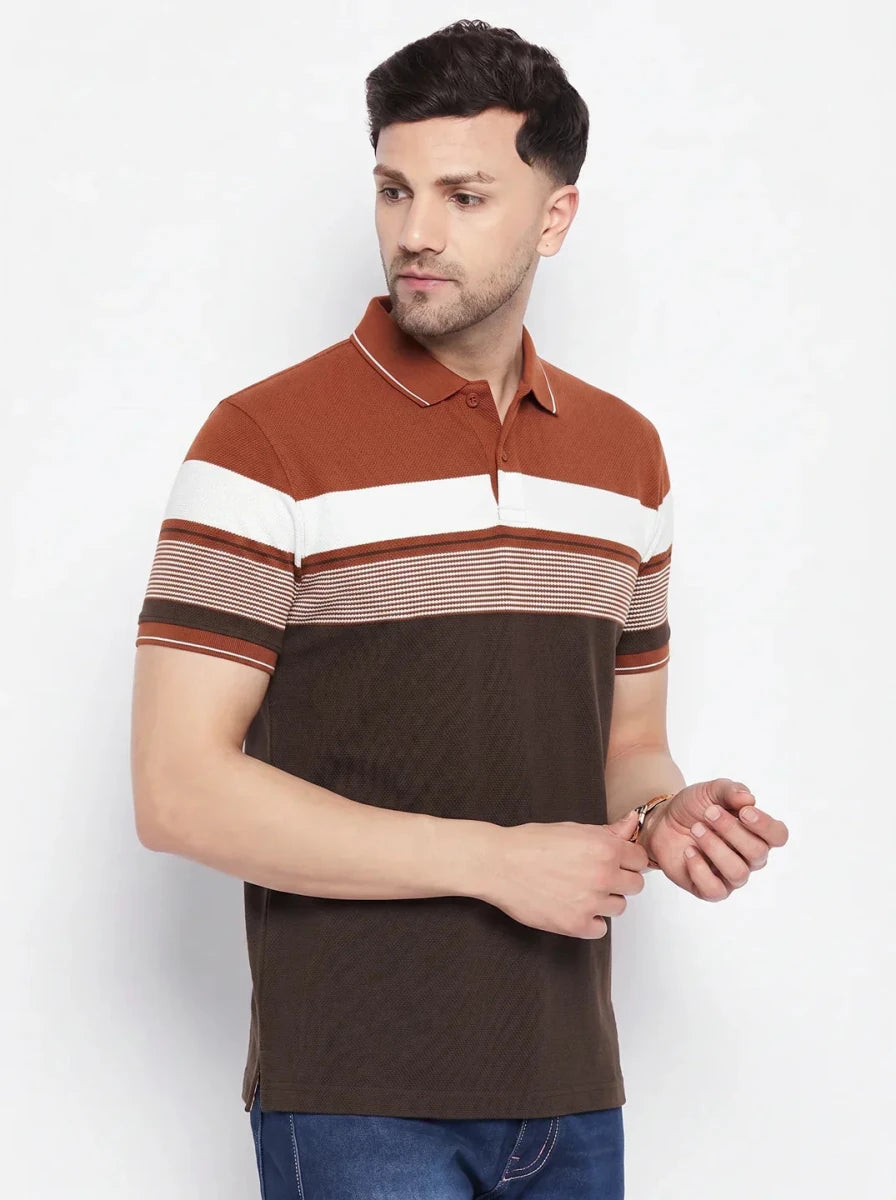 Man wearing 98degreenorth Men's Rust Brown Striped Polo T-Shirt with blue jeans, standing against a white background.