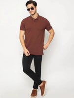 Man in 98degreenorth Men's Rust Solid Polo T-Shirt, black jeans, and brown sneakers against a white background.