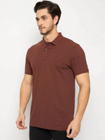 Man wearing a 98degreenorth Men's Rust Solid Polo T-Shirt, Cotton Pique, with black pants against a white background.
