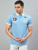 Man in Men's Sky Blue Aeronorth KC-767A Aviation Polo T-Shirt by 98degreenorth, ideal for aviation fans, gray backdrop.