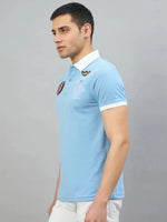 Man wearing a men's Sky Blue Aeronorth KC-767A Aviation Polo T-Shirt by 98degreenorth on a plain gray background.