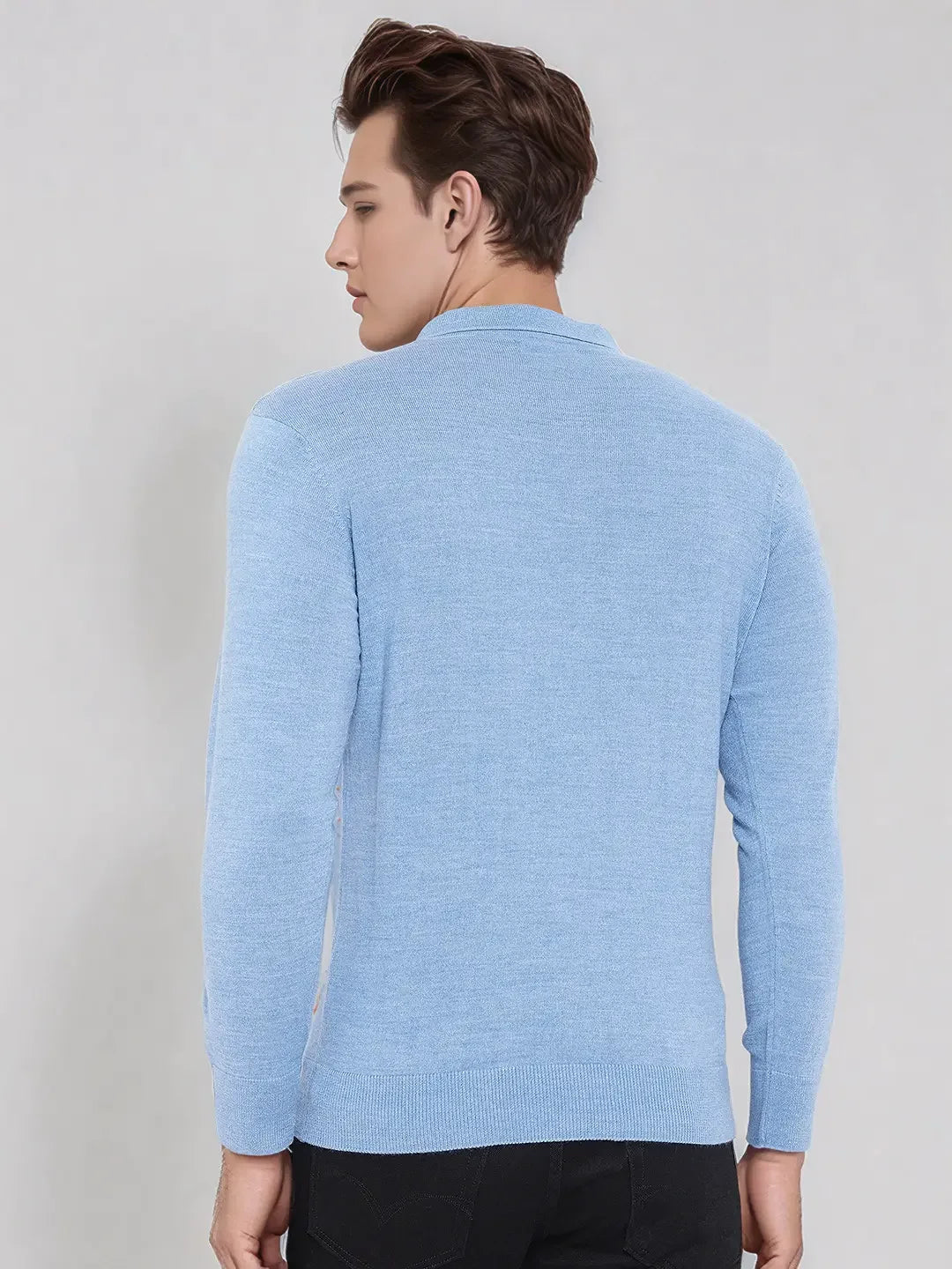 Man with short brown hair wears a 98degreenorth Men’s Sky Blue Merino Wool Polo Sweater, facing away on a plain background.