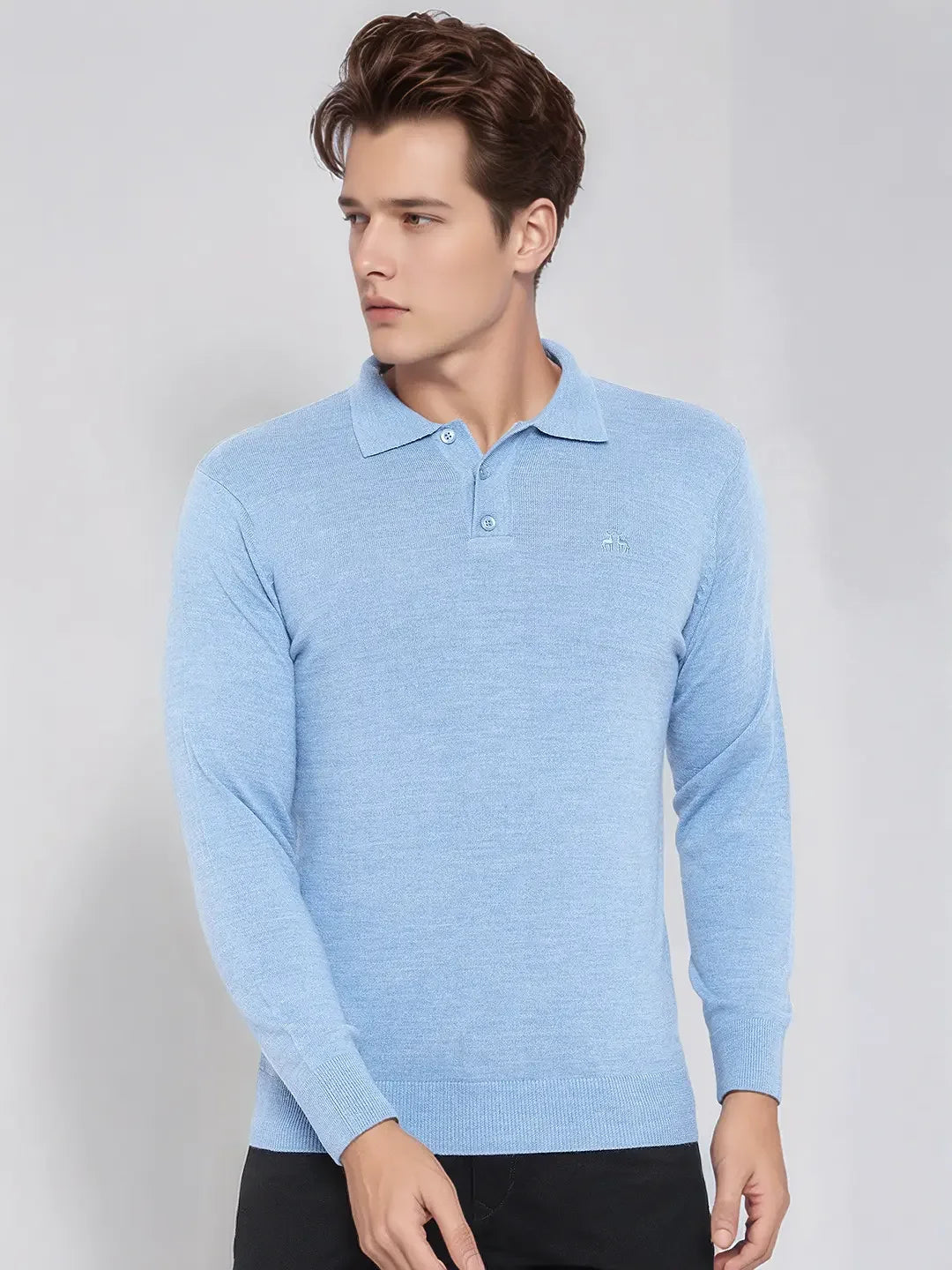 A man in a 98degreenorth Men’s Sky Blue Merino Wool Polo Sweater stands against a plain gray background, looking left.
