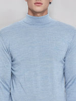 Man in a 98degreenorth men’s sky blue merino wool turtleneck sweater with embroidered logo on the left chest.