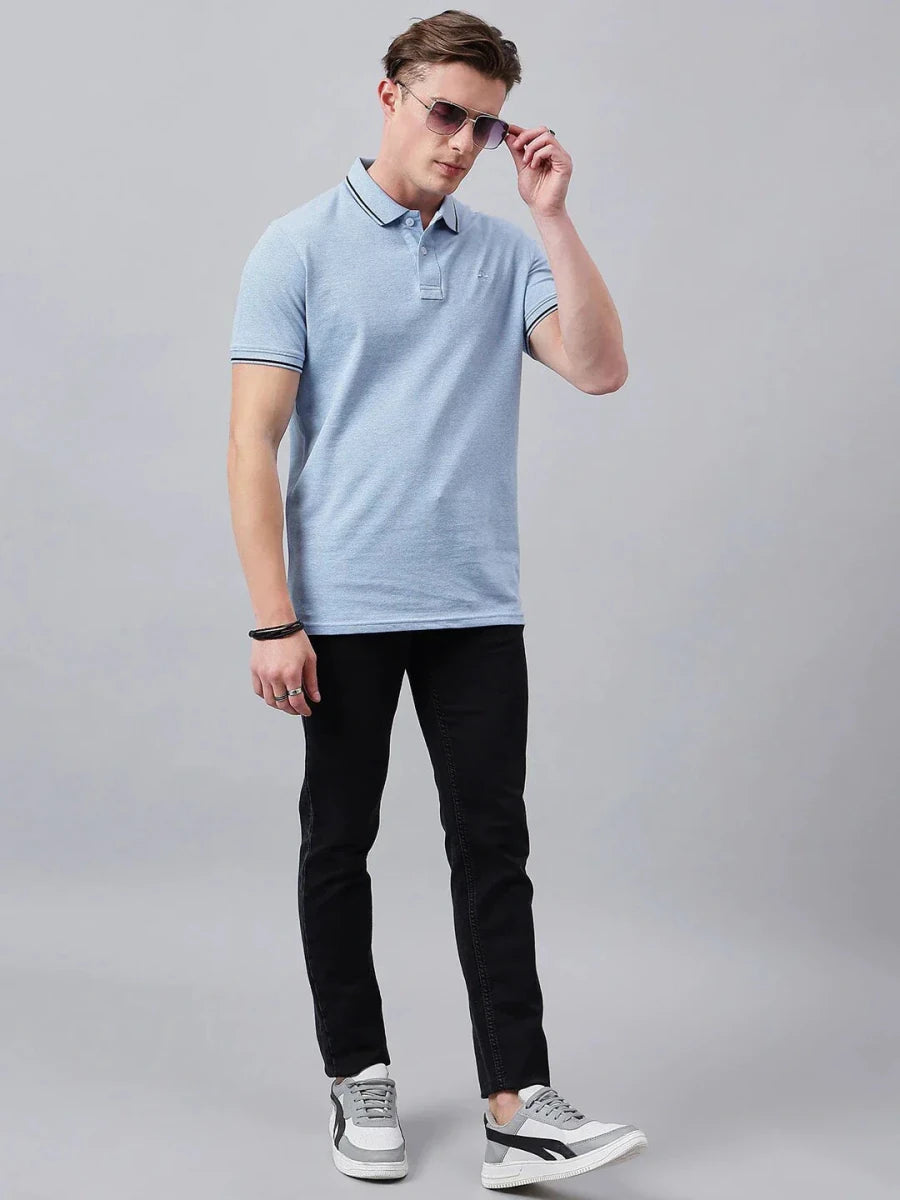 Man in a 98degreenorth Men's Sky Blue Solid Polo T-Shirt (Cotton Pique) adjusts sunglasses against a gray background.