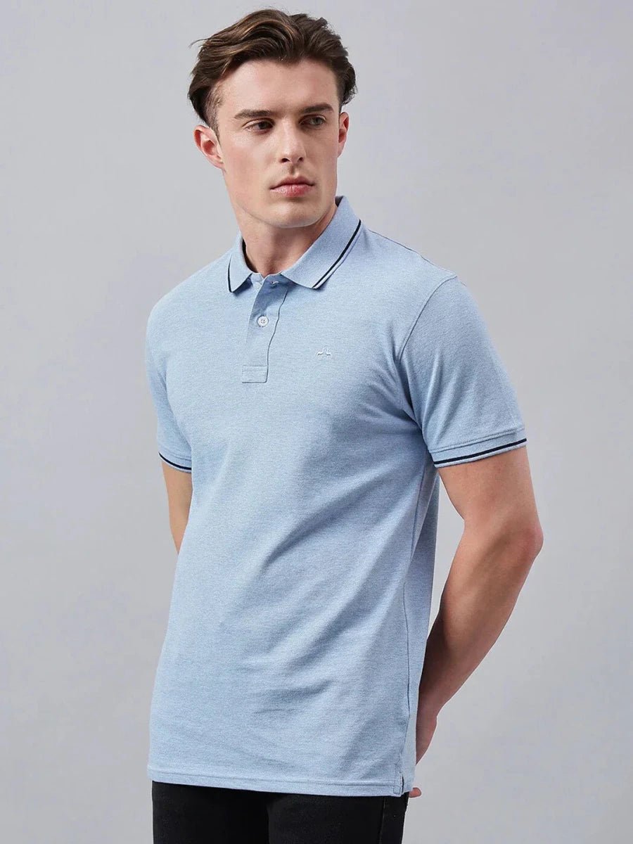 Man in 98degreenorth Men's Sky Blue Solid Cotton Pique Polo, standing against a plain light gray background.