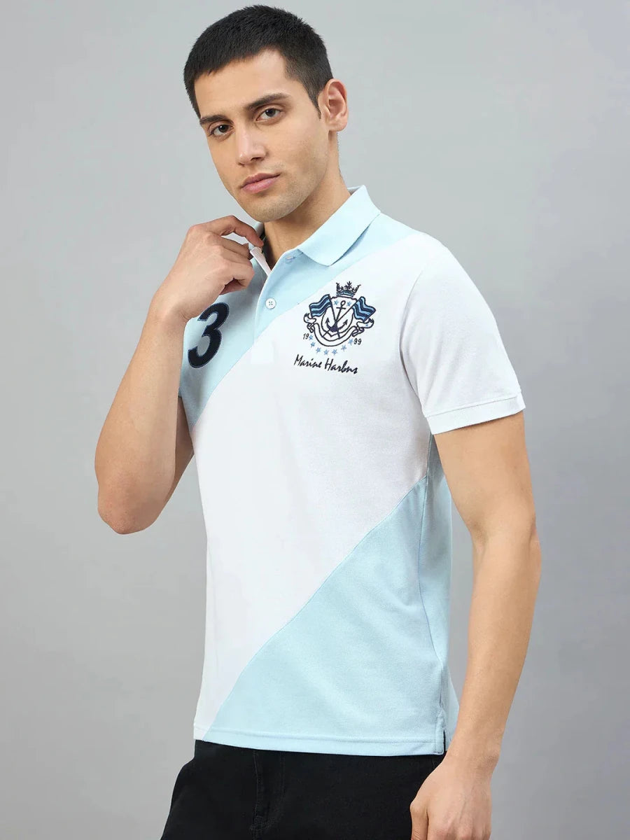 Man in 98degreenorth Men's Sky Blue & White Colour Block Polo with Marine Harbns embroidery, posing plain background.