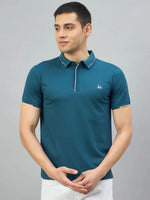 Man in 98degreenorth Men's Teal Polo T-Shirt with white tipping and LA logo, against a gray background.