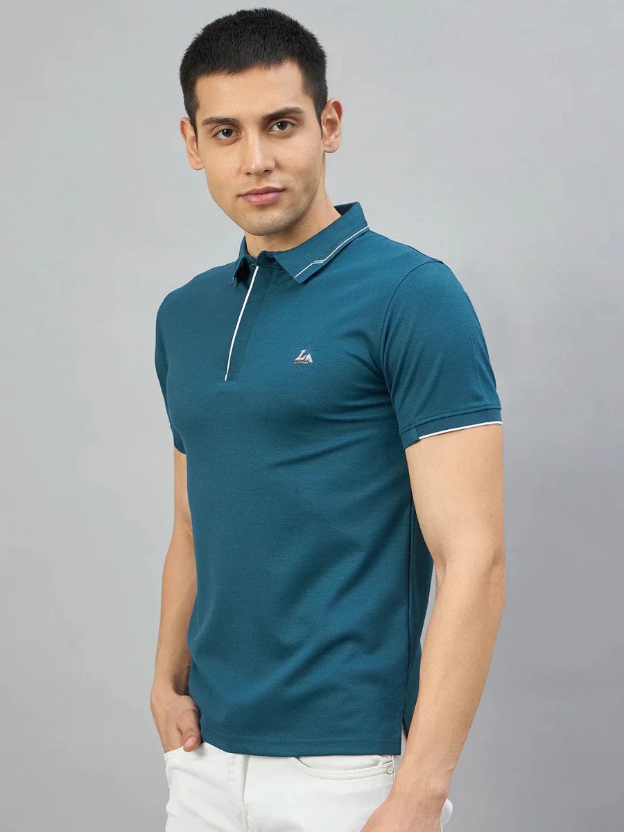 Man in 98degreenorth Men’s Teal Polo T-Shirt with White Tipping & LA logo, posed against a grey background.