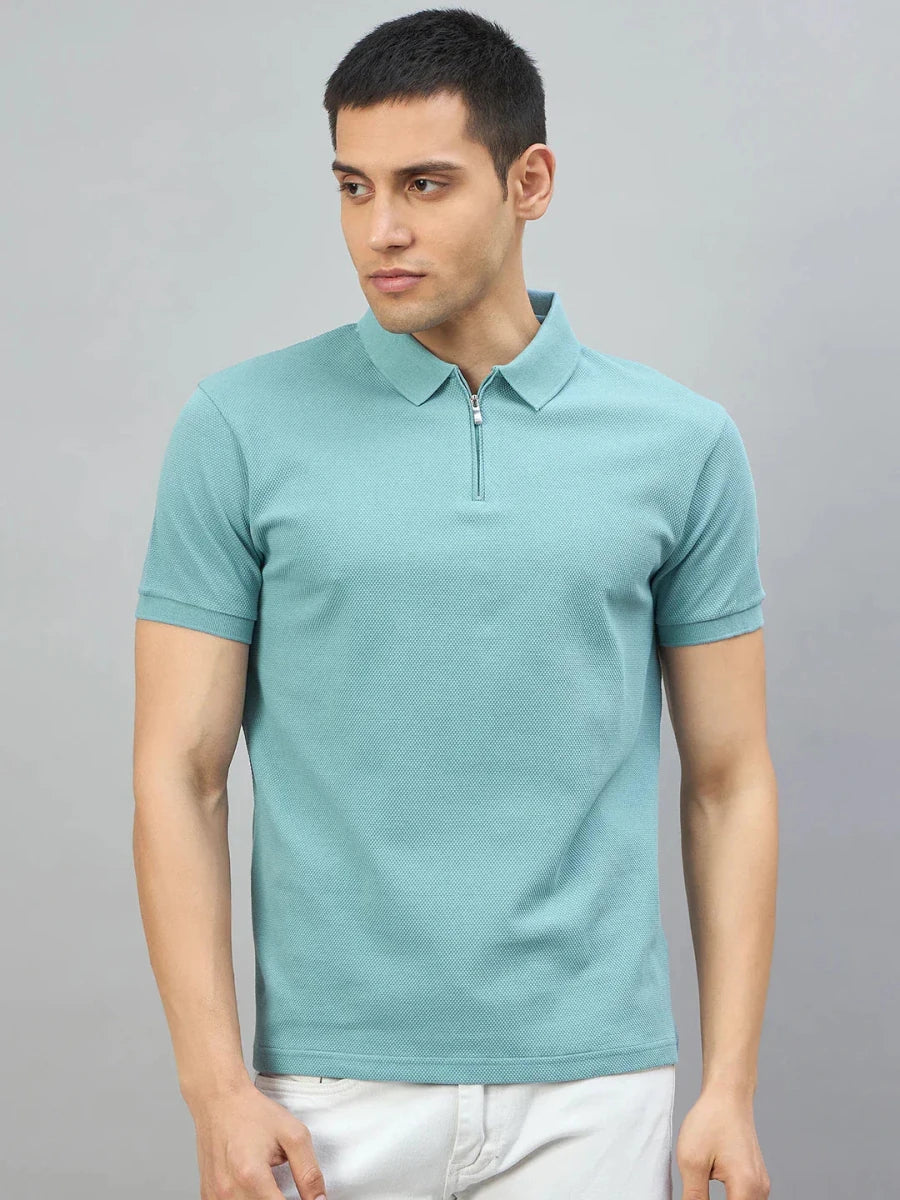 Man wears 98degreenorth Men's Turquoise Quarter Zip Polo T-Shirt—Popcorn Knit, against a gray background.