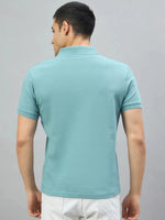 Man in 98degreenorth Men's Turquoise Quarter Zip Polo T-Shirt — Popcorn Knit, facing away from camera.