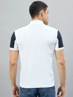Man wears a Men's White Black Sleeve Aeronorth 91ª Polo T-Shirt by 98degreenorth, back to camera on gray background.