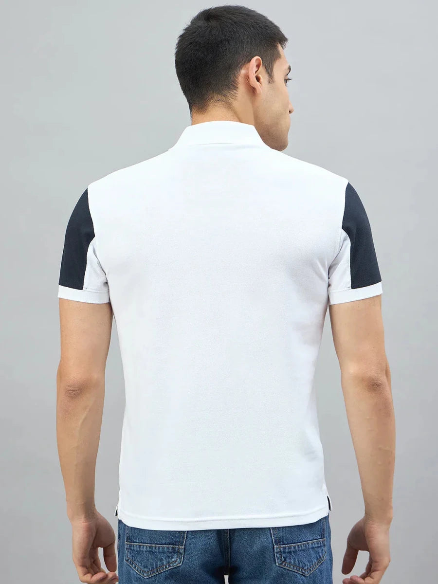 Man wears a Men's White Black Sleeve Aeronorth 91ª Polo T-Shirt by 98degreenorth, back to camera on gray background.
