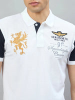 Man in 98degreenorth Men's White Black Sleeve Aeronorth 91ª Polo T-Shirt with gold griffin logo embroidery.
