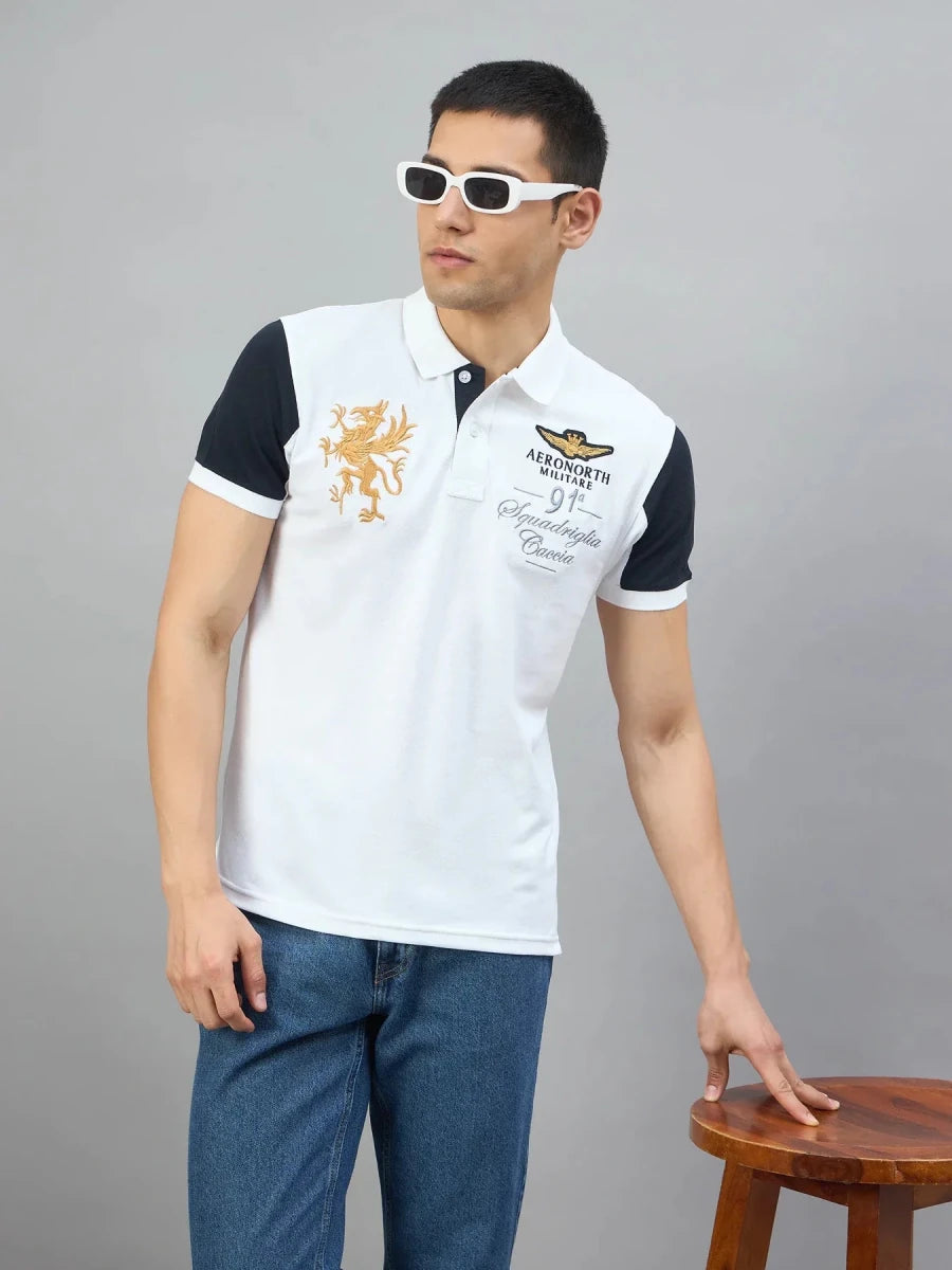 A man in sunglasses and a Men's White Black Sleeve Aeronorth 91ª Polo T-Shirt by 98degreenorth poses on a stool.